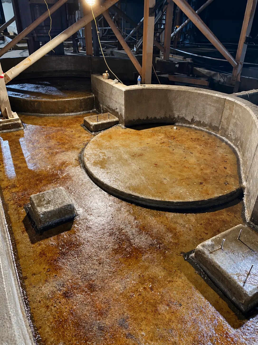 Wet acid-resistant lining on a concrete bunded structure at night