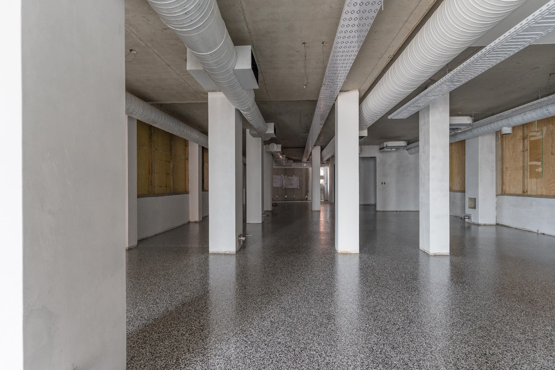 Speckled industrial resin floor with columns and ducting